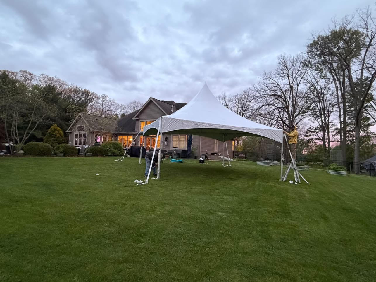 White event tent being installed on a lawn